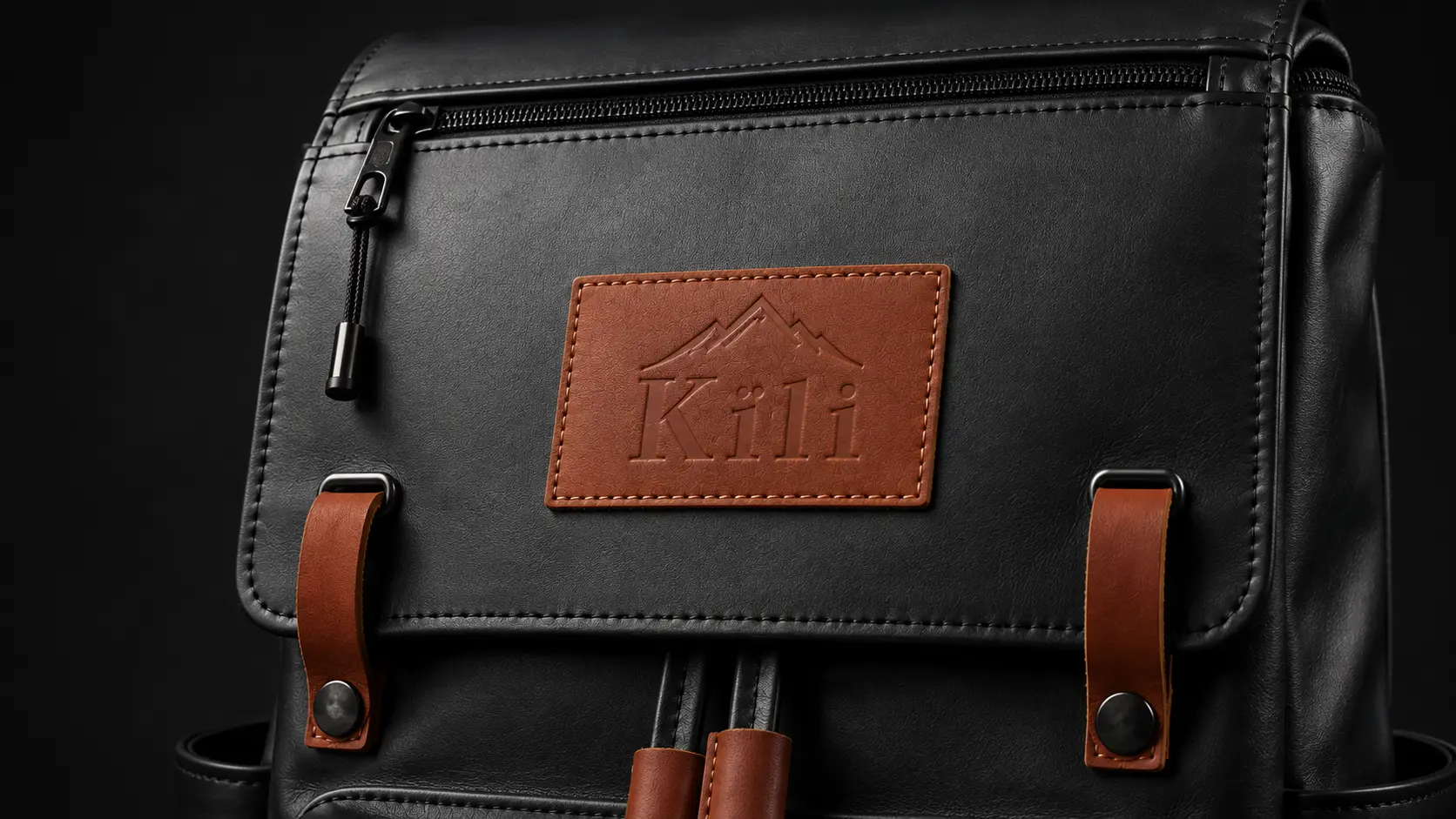 Macro detail of the Kïli full-grain leather patch and solid brass buckle strap